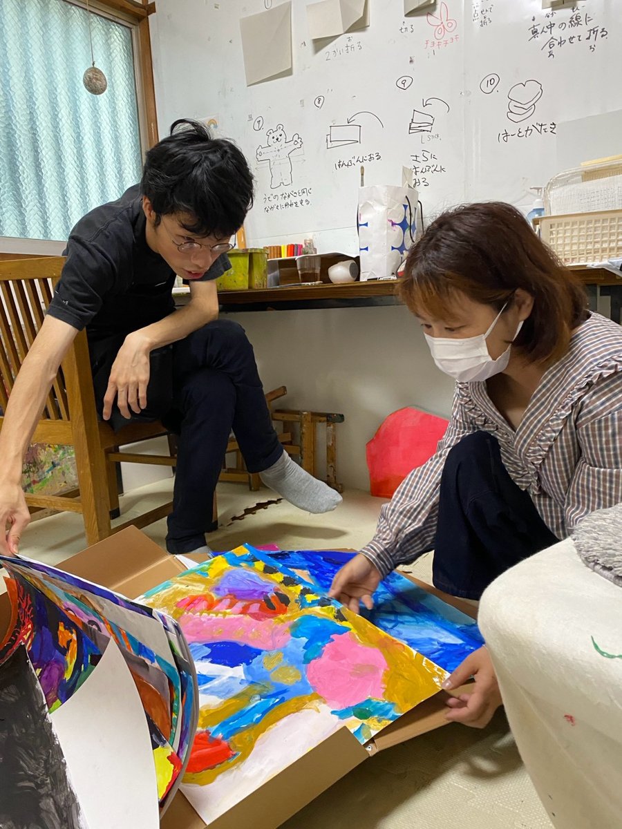 大きな絵を二人で広げて見る様子